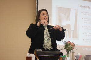 Christina Fielder demonstrating the proper way to hold silverware while cutting. 